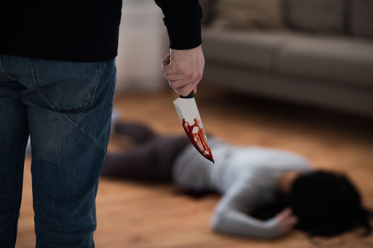 uomo con un coltello insanguinato