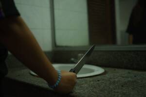 donna allo specchio con coltello