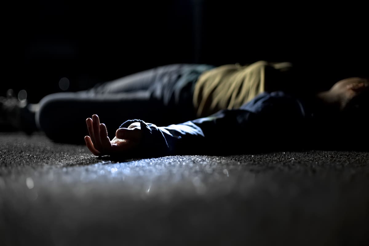 cadavere di una donna morta steso in strada