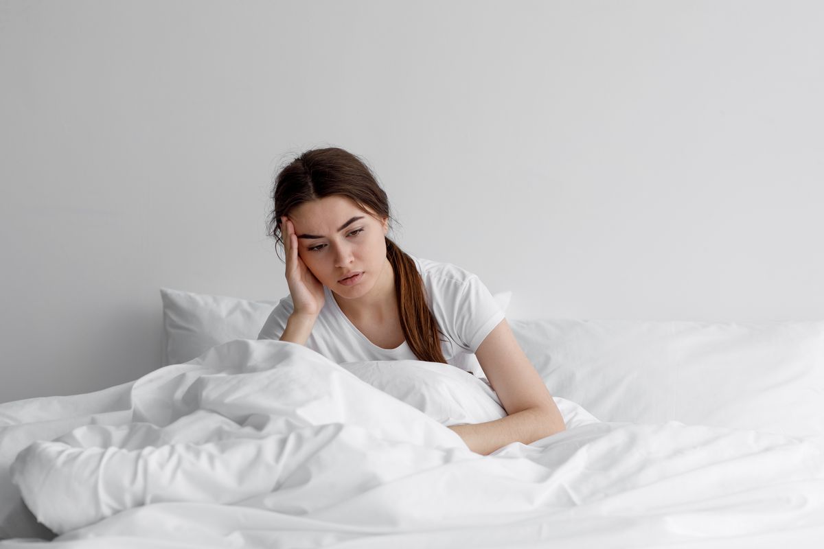 ragazza stanca seduta sul letto