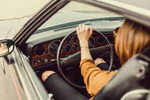 Donna che guida auto seduta al volante