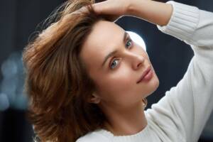 Donna castana con mano tra i capelli