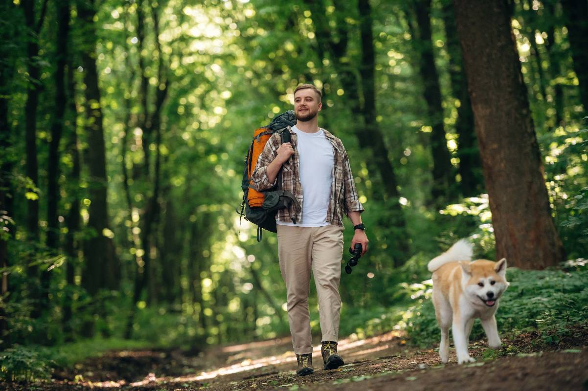 Padrone in passeggiata col proprio cane senza guinzaglio.