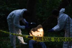la scientifica analizza la scena del crimine con un cadavere