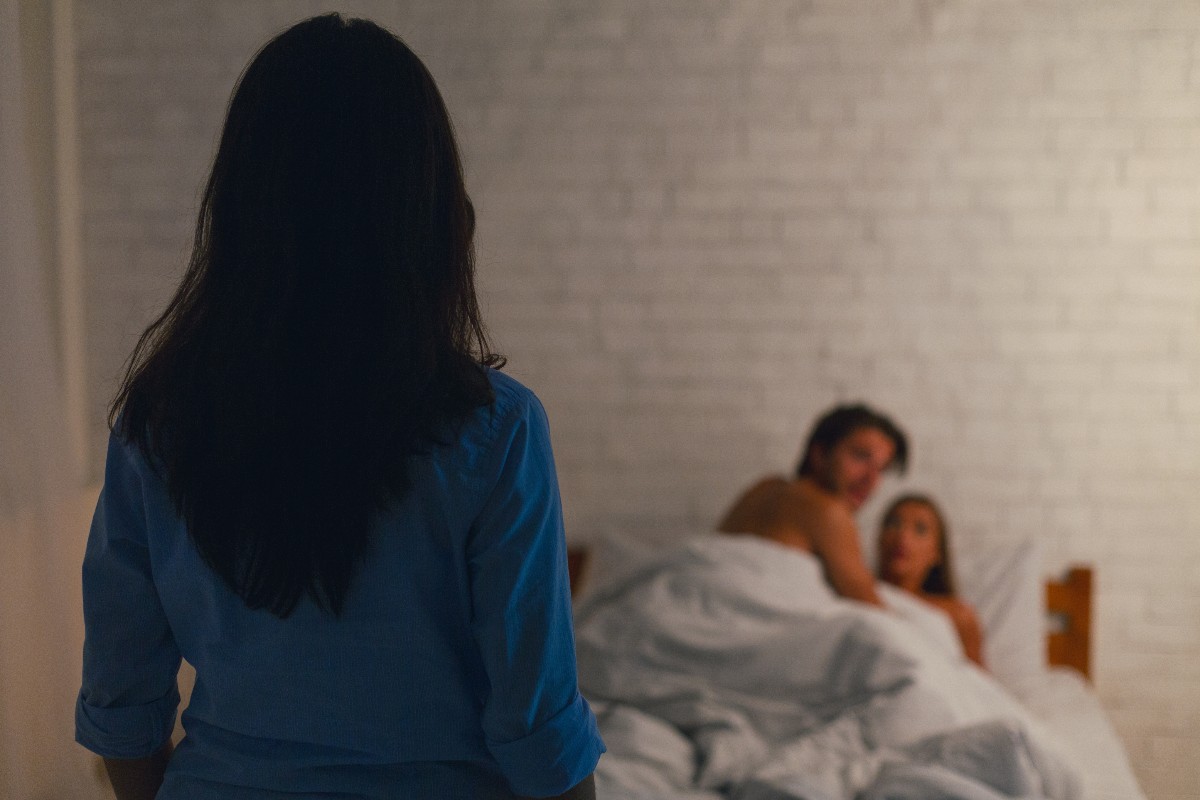 Donna di schiena che guarda una coppia a letto